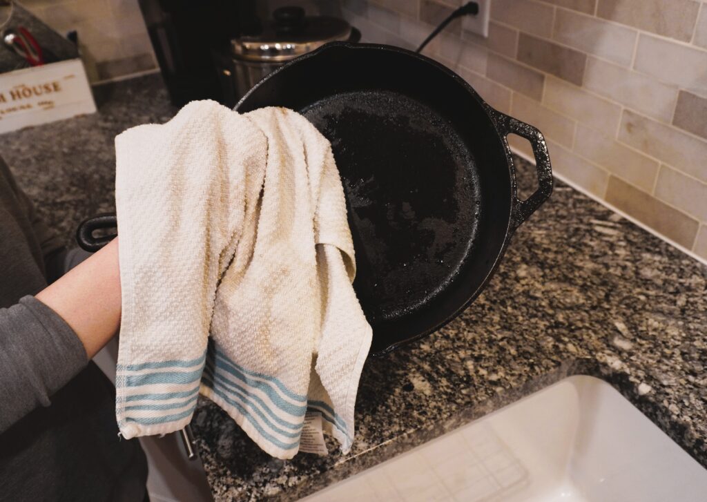 dry off a cast iron skillet with a white dish towel
