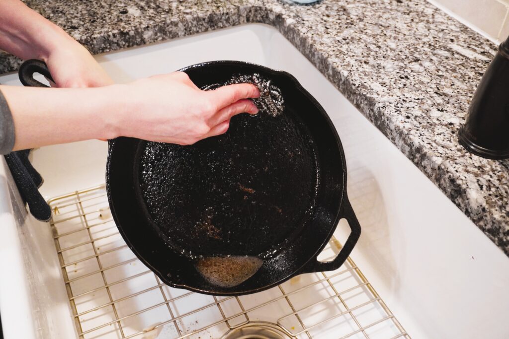 washing a cast iron skillet using a stainless steel scrubber