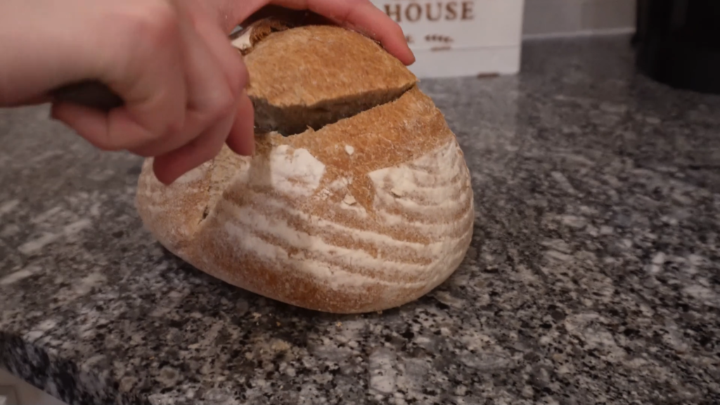 cutting off the top of a piece of sour dough bread