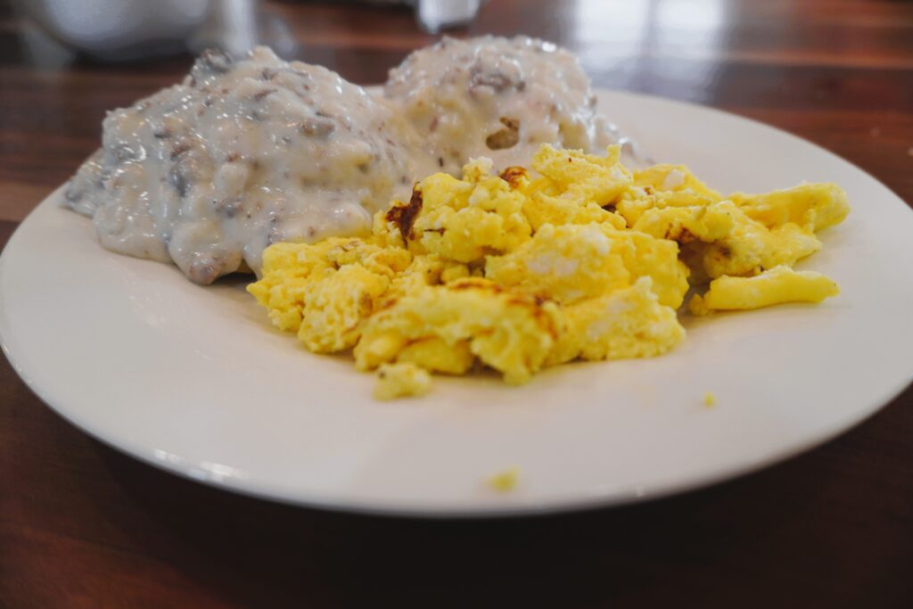 plate with biscuits and gravy and scrambled eggs