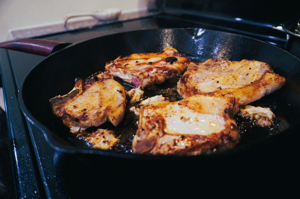 cooked pork chops in a cast iron skillet