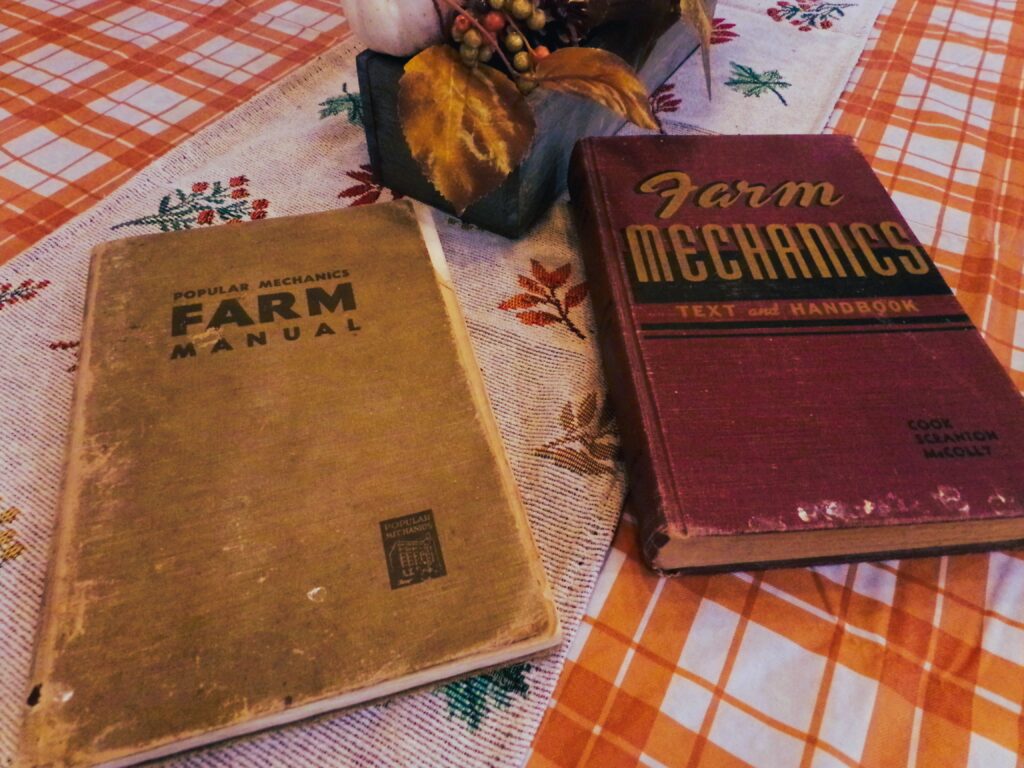 Two old farm mechanic books sitting on a kitchen table