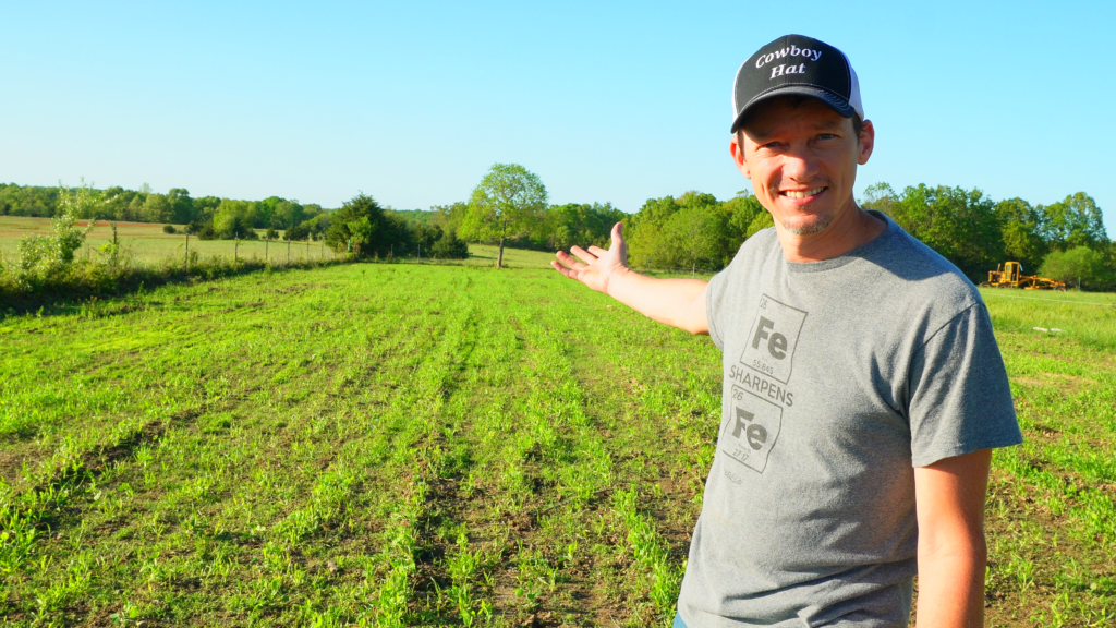 Man with arm out in an open field