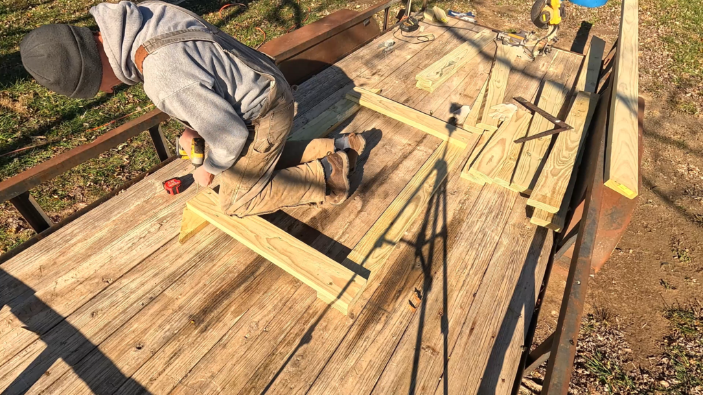 Man screwing boards together on a trailer