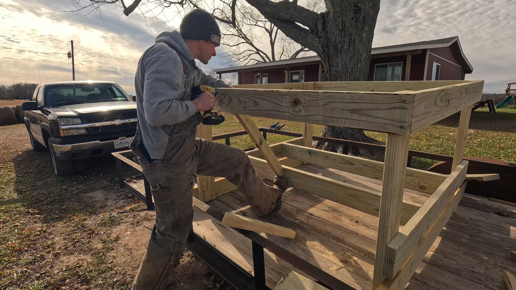 Man putting together DIY round bale feeder