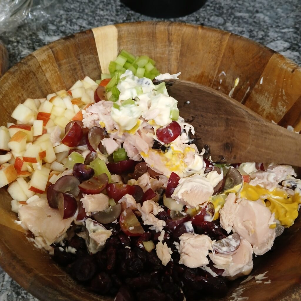 Ingredients for chicken salad in a wooden bowl